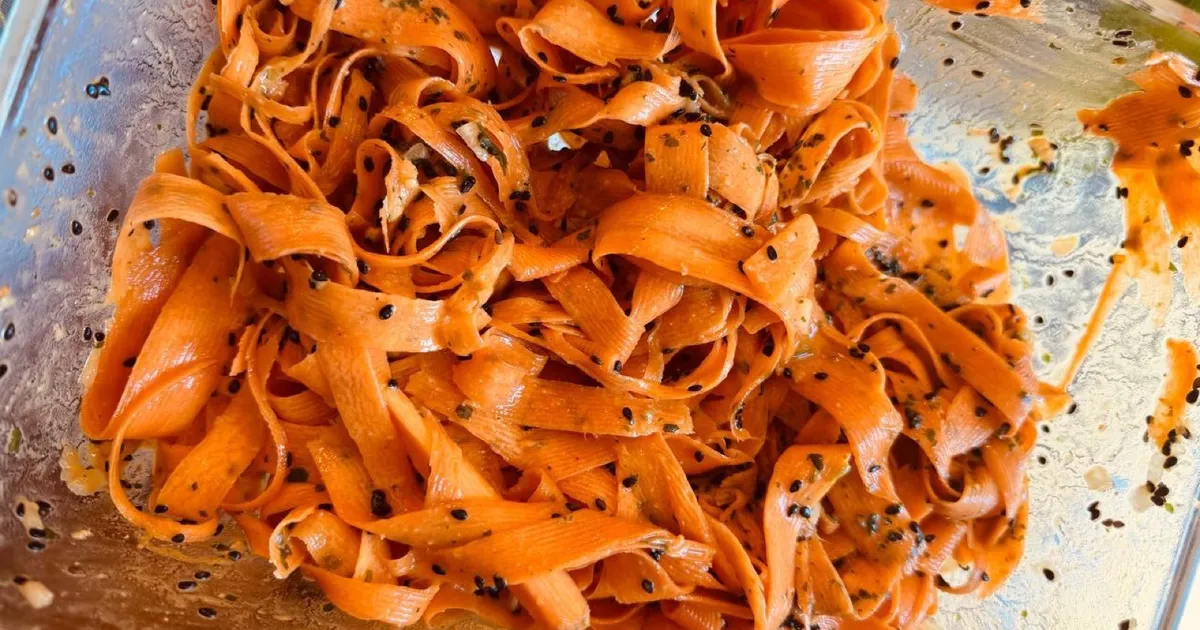 Flotter Karottensalat mit gehobelten Karottenbändern, schwarzem Sesam und Kräutern