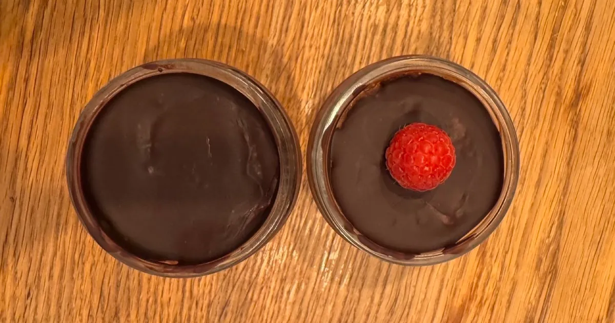 Schoko-Chia-Pudding in zwei Gläsern mit Schokoschicht und frischer Himbeere